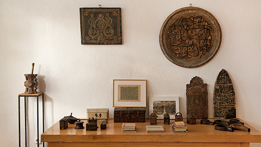On the left coffee boxes, on the right coolers seen on the table. In front of the wall is Hilya Sharif and just next to it one sees a panel of a dervish lodge.